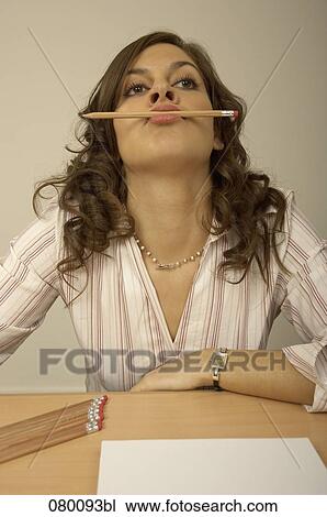 bored businesswoman holding pencil in her mouth View Large Photo Image Stock Image - bored businesswoman holding pencil in her mouth. Fotosearch