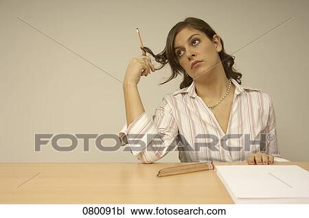 bored businesswoman sitting at desk holding pencil View Large Photo Image Stock Image - bored businesswoman sitting at desk holding pencil. Fotosearch