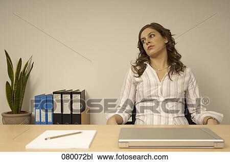 Stock Image - bored secretary sitting at desk. Fotosearch