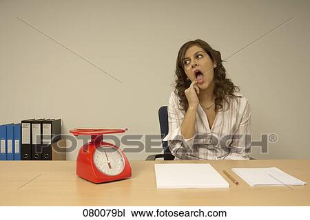 bored secretary sitting at desk with red scales and documents View Large Photo Image Stock Image - bored secretary sitting at desk with red scales and documents. Fotosearch