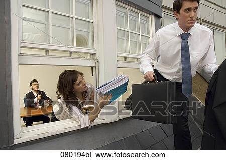 businessman leaving escaping from meeting room female colleague trying to give him file View Large Photo Image Stock Image - businessman leaving escaping from meeting room female colleague trying to give him file. Fotosearch