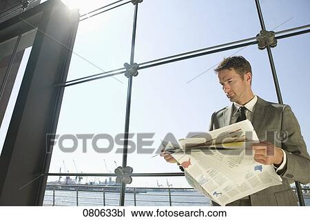 businessman reading newspaper in front of window View Large Photo Image Stock Image - businessman reading newspaper in front of window. Fotosearch