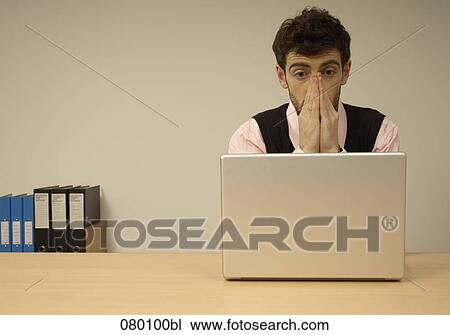 businessman sitting at desk behind laptop computer having a problem View Large Photo Image Stock Image - businessman sitting at desk behind laptop computer having a problem. Fotosearch