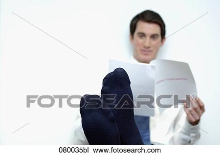 businessman sitting at desk with feet up reading document View Large Photo Image Stock Image - businessman sitting at desk with feet up reading document. Fotosearch