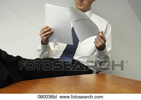 businessman sitting at desk with feet up reading document View Large Photo Image Stock Image - businessman sitting at desk with feet up reading document. Fotosearch