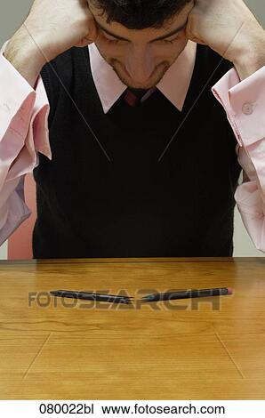 businessman sitting at table head in hands with broken pencil in foreground View Large Photo Image Stock Image - businessman sitting at table head in hands with broken pencil in foreground. Fotosearch