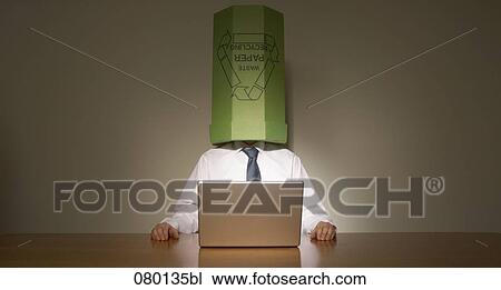 businessman sitting behind computer with wastebasket over his head View Large Photo Image Stock Image - businessman sitting behind computer with wastebasket over his head. Fotosearch