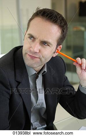 Stock Image - businessman sticking pencil in his ear. Fotosearch