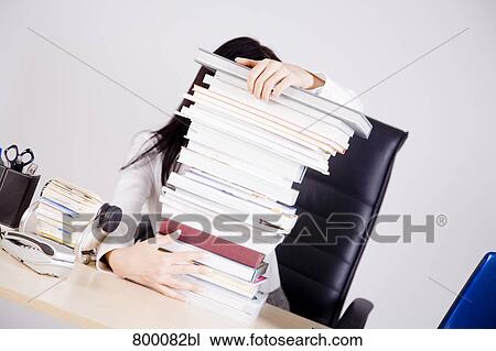 businesswoman sitting on desk hidden behind pile of books View Large Photo Image Stock Image - businesswoman sitting on desk hidden behind pile of books. Fotosearch