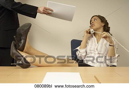 businesswoman talking on telephone with colleague disturbing her View Large Photo Image Stock Image - businesswoman talking on telephone with colleague disturbing her. Fotosearch