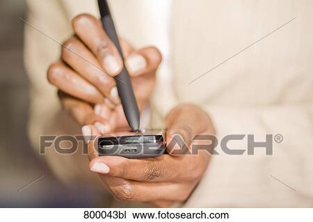close-up of black businesswoman typing text message with pen on mobile phone View Large Photo Image Stock Image - close-up of black businesswoman typing text message with pen on mobile phone. Fotosearch