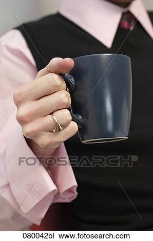 Stock Image - close-up of businessman holding mug. Fotosearch