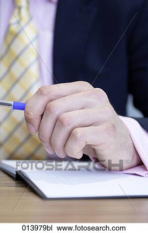 Stock Image - close-up of businessman´s hand holding pen. Fotosearch