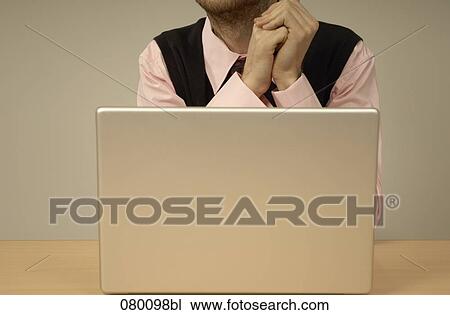 close-up of businessman sitting behind laptop computer View Large Photo Image Stock Image - close-up of businessman sitting behind laptop computer. Fotosearch