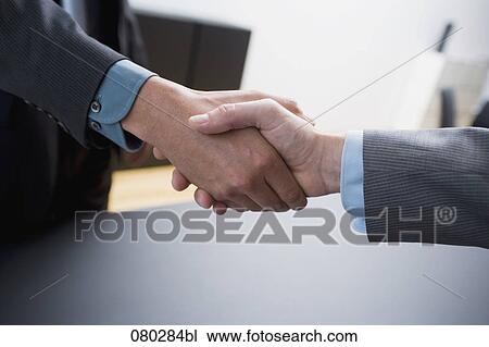 Stock Image - close-up of two businessmen shaking hands. Fotosearch
