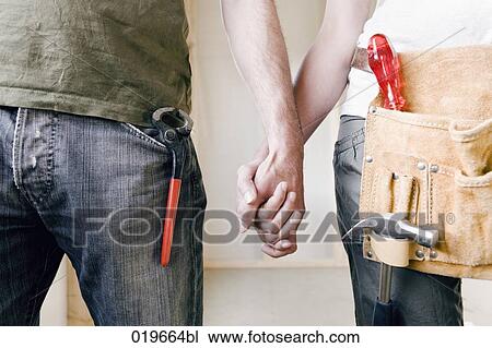 close-up of young couple with construction tools holding hands View Large Photo Image Stock Image - close-up of young couple with construction tools holding hands . Fotosearch