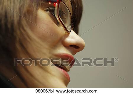Stock Image - close-up of young woman wearing glasses in profile. Fotosearch