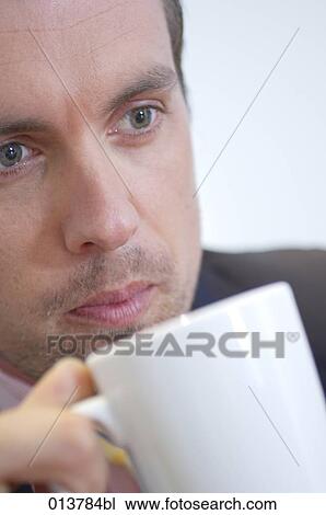 Stock Image - close-up portrait of businessman with coffee cup. Fotosearch
