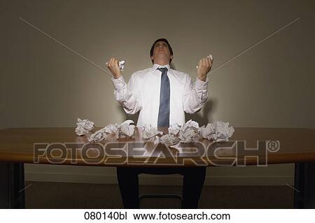 desperate businessman sitting at desk full with paper balls View Large Photo Image Stock Image - desperate businessman sitting at desk full with paper balls. Fotosearch