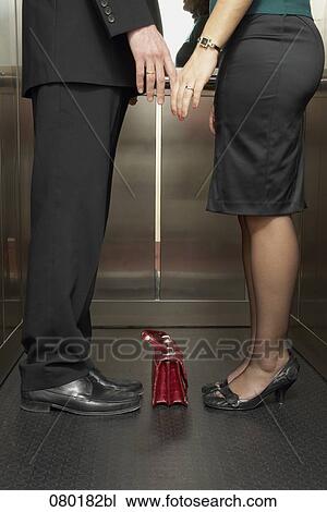detail of business couple standing together in elevator tenderly touching hands View Large Photo Image Stock Image - detail of business couple standing together in elevator tenderly touching hands . Fotosearch