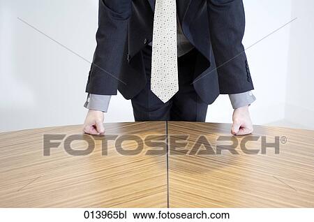 Stock Image - detail of businessman in suit and tie leaning on table. Fotosearch