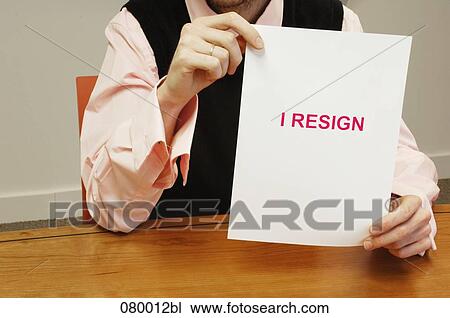 detail of businessman sitting at desk holding resign document View Large Photo Image Stock Image - detail of businessman sitting at desk holding resign document. Fotosearch