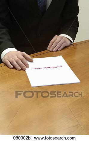 detail of businessman sitting at table with confidential document View Large Photo Image Stock Image - detail of businessman sitting at table with confidential document. Fotosearch