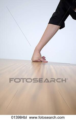 Stock Image - detail of female arm resting on table. Fotosearch