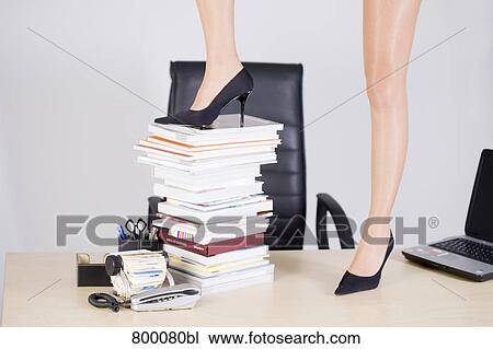 detail of young businessman wearing high heel shoes putting one foot on pile of books View Large Photo Image Stock Image - detail of young businessman wearing high heel shoes putting one foot on pile of books. Fotosearch