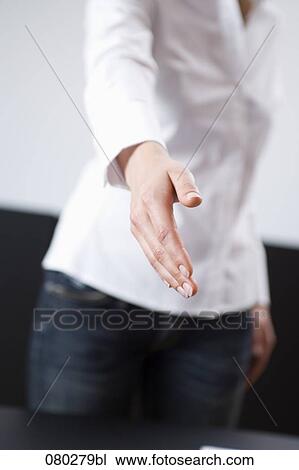 Stock Image - detail of young businesswoman reaching out her hand for welcome. Fotosearch