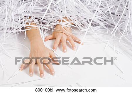 Stock Image - detail of young woman buried under shredded paper. Fotosearch