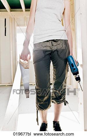 Stock Image - detail of young woman with construction tools. Fotosearch