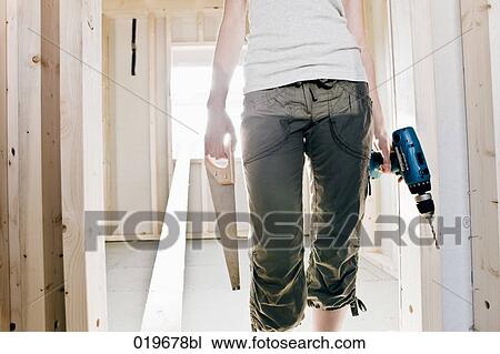 Stock Image - detail of young woman with construction tools. Fotosearch