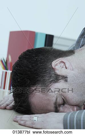 exhausted businessman laying his head on the table sleeping View Large Photo Image Stock Image - exhausted businessman laying his head on the table sleeping. Fotosearch
