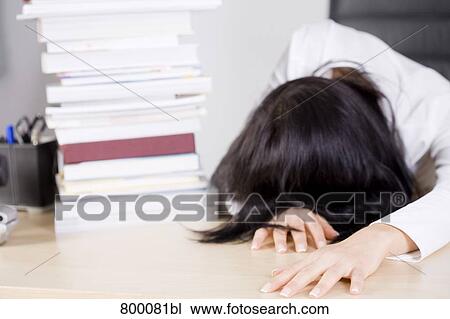 exhausted businesswoman lying on desk beside pile of books View Large Photo Image Stock Image - exhausted businesswoman lying on desk beside pile of books. Fotosearch