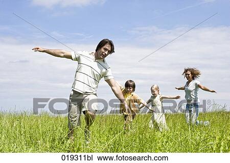 family playing in meadow View Large Photo Image Stock Image - family playing in meadow. Fotosearch