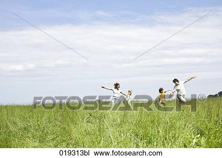 Stock Image - family playing in meadow. Fotosearch