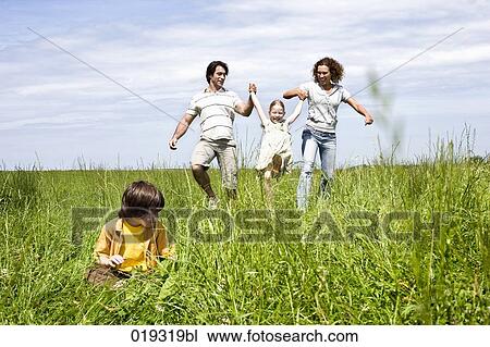 family playing in meadow View Large Photo Image Stock Image - family playing in meadow. Fotosearch