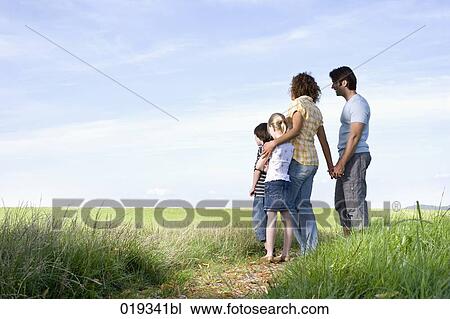 family standing on path in the countryside looking at the horizon View Large Photo Image Stock Image - family standing on path in the countryside looking at the horizon. Fotosearch