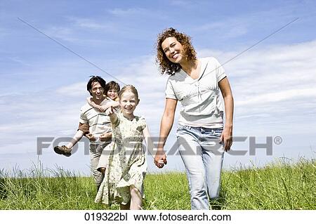 Stock Image - family walking on meadow. Fotosearch