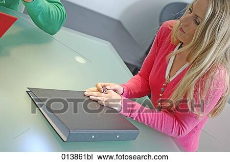 female executive sitting with folder at conference table View Large Photo Image Stock Image - female executive sitting with folder at conference table. Fotosearch