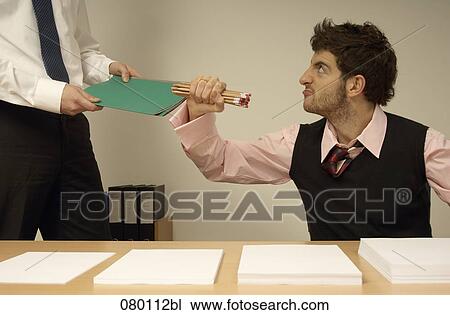 frustrated businessman sitting at desk full of documents colleague giving him file View Large Photo Image Stock Image - frustrated businessman sitting at desk full of documents colleague giving him file. Fotosearch