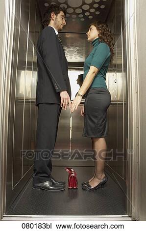 full body portrait of business couple standing together in elevator tenderly touching hands View Large Photo Image Stock Image - full body portrait of business couple standing together in elevator tenderly touching hands . Fotosearch
