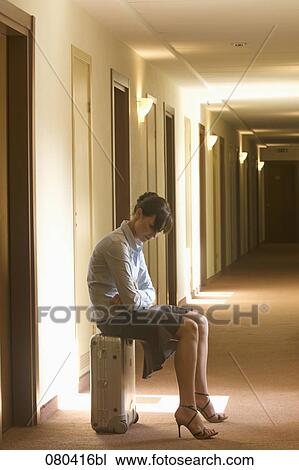 full body portrait of young businesswoman sitting on suitcase in hotel corridor View Large Photo Image Stock Image - full body portrait of young businesswoman sitting on suitcase in hotel corridor. Fotosearch