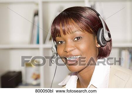Stock Image - headshot of black businesswoman wearing headset. Fotosearch