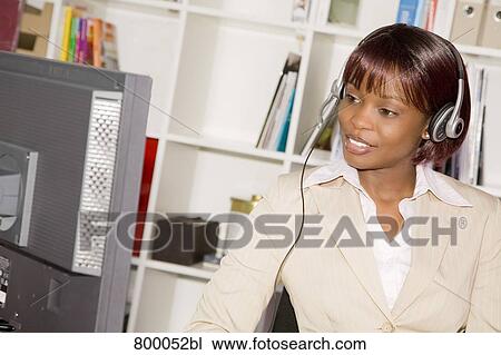 headshot of black businesswoman wearing headset working with computer View Large Photo Image Stock Image - headshot of black businesswoman wearing headset working with computer. Fotosearch