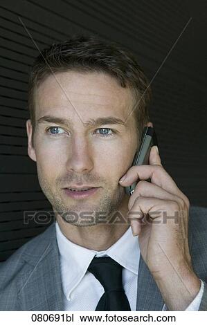 Stock Image - headshot of business talking on mobile phone. Fotosearch