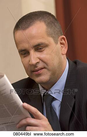 headshot of mature businessman sitting in hotel lobby reading newspaper View Large Photo Image Stock Image - headshot of mature businessman sitting in hotel lobby reading newspaper. Fotosearch