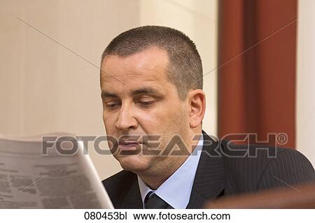 headshot of mature businessman sitting in hotel lobby reading newspaper View Large Photo Image Stock Image - headshot of mature businessman sitting in hotel lobby reading newspaper. Fotosearch