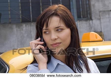 headshot of young businesswoman in front of yellow taxi talking on mobile phone View Large Photo Image Stock Image - headshot of young businesswoman in front of yellow taxi talking on mobile phone. Fotosearch